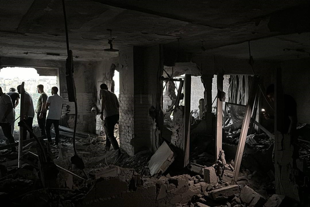 مواطنون يتفقدون الدمار الذي لحق في شقة المعتقل أيسر البرغوثي عقب تفجيرها 